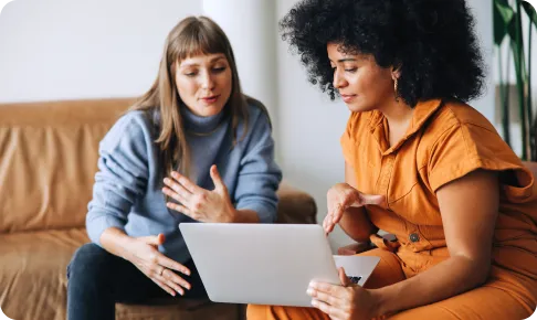 Two female colleagues looking at laptop